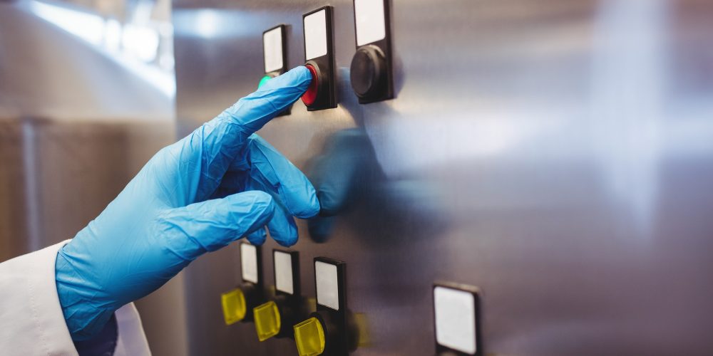 Manufacturer hand on control panel in brewery